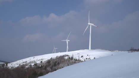 Wind-power-plants-are-seen-in-the-snow-covered-mountain,-South-Korea