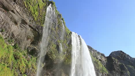 Icelandic-waterfall,-famous-tourist-attraction,-A-view-at-the-top-of-cascade-where-it-burst-out-from-the-top-of-the-mountain,-Seljalandsfoss-in-south-Iceland