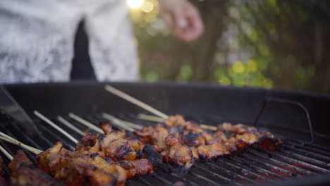 Indonesian-woman-grills-chicken-satay-over-charcoal-in-her-back-yard