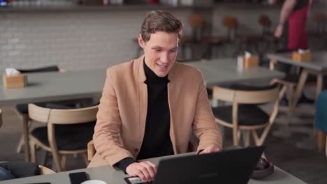 guy-in-cafe-talking-on-video-on-laptop