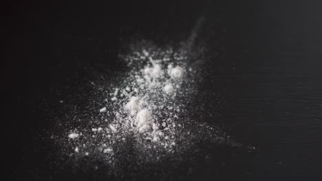 White-powder-falling-on-top-of-a-table,-crushed-pills