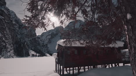 Cabaña-De-Madera-Cubierta-De-Nieve-Junto-Al-Lago-Congelado-Braies,-Dolomitas-Paisaje-Invernal