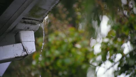 Wasser,-Das-Von-Der-Dachkante-Fällt,-Mit-Einem-Schönen-Hintergrund-Regentropfen-Abflussrohr
