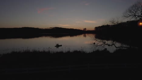 Silhouetten-Drohnenaufnahmen-Eines-Fischers-Auf-Dem-See-Bei-Sonnenuntergang