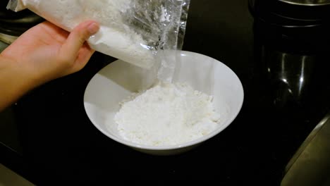 Weißes-Mehl-Aus-Plastiktüte-In-Schüssel-Gießen,-Nahaufnahme