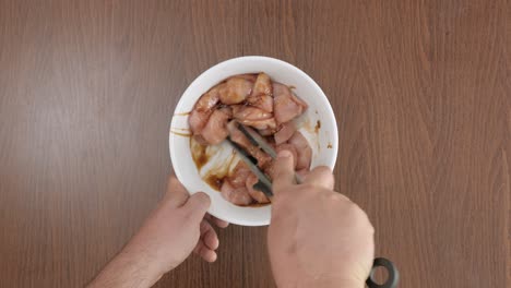 Man-seasoning-chicken-with-soy-sauce