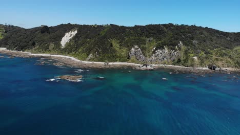 Drone-flying-over-of-Mangawhai-Heads-on-a-beautiful-day,-moving-left-to-right,-with-an-overall-view-of-the-scenic-view