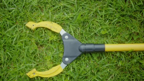 a-yellow-pincher-on-the-grass,forceps,tongs,clamp,pliers-lying-on-the-grass