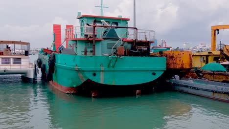 Green-Tugboat-Moored-In-A-Marina