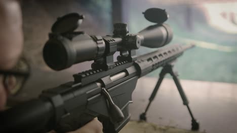Shooter-firing-sniper-rifle-on-shooting-range,-close-up-on-weapon