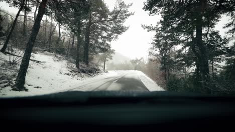 View-from-car-front-window-on-snowy-road-in-winter-scenery-at-snowfall