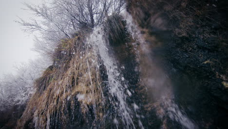 Eiskalter-Wasserfall,-Frost-Auf-Bäumen-Und-Gras,-Verschneite-Winterlandschaft