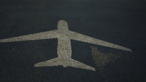 Airplane-sign-painted-on-airport-runway,-close-up