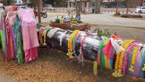 Multicolored-Dresses-Hanging-In-The-Park-With-Horizontal-Tree-Log-Decorated-With-Lei-And-Colorful-Strips-Of-Cloth