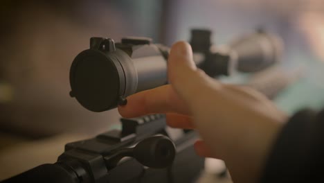 Close-up-on-finger-opening-scope-cover-of-sniper-precision-rifle