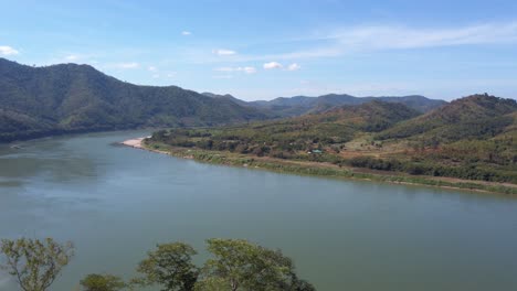 Mekong-River-Surrounded-With-Green-Mountains-Under-Bright-Blue-Sky-In-Summer-In-Thailand