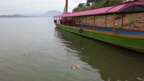 Ein-Leeres-Langheckboot-Aus-Holz,-Das-Auf-Einer-Ruhigen-See-In-Der-Nähe-Einer-Felsigen-Küste-In-Thailand-Andockt---Mittlere-Aufnahme,-Statisch
