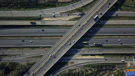 Aerial-shot-of-car-traffic-driving-along-busy-city-urban-highway-interchange-zoom-out