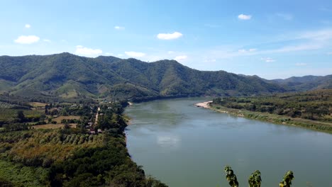 Wunderschöne-Landschaft-Des-Mekong-Flusses-Mit-Herrlichen-Bäumen-Unter-Dem-Strahlend-Blauen-Himmel-Oben---Luftaufnahme