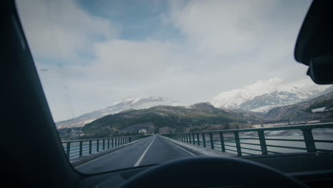 Mountain-panorama-from-front-window-of-car-driving-on-lake-bridge-road