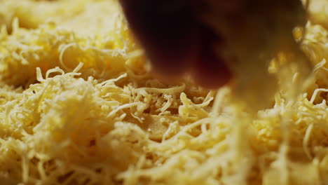 Grated-parmesan-cheese,-shredded-Parmigiano-Reggiano-ingredient,-macro-close-up