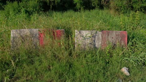 Old-Jersey-Barriers-Surrounded-By-Tall-Green-Grass-In-Thailand