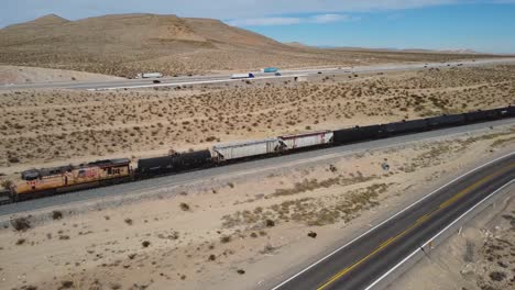 Aerial-view-over-Nevada-desert-landscape-with-freeways-and-train-railroad
