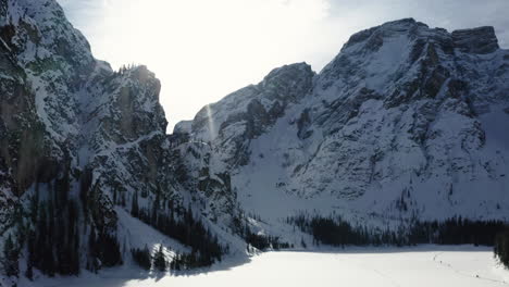 Paisaje-Montañoso-De-Invierno-Nevado-Iluminado-Por-El-Sol,-Lago-Congelado-Braies,-Dolomitas
