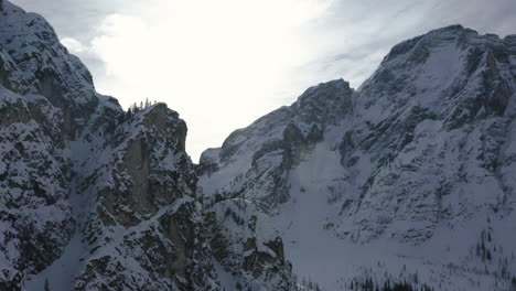 Rocky-summit-of-Braies-Dolomites-in-snow,-alpine-mountain-steep-slopes-aerial