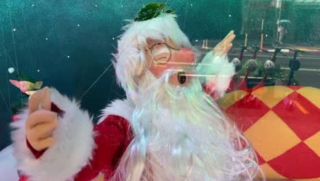 Weihnachtsmann-Im-Schaufenster,-Der-Durch-Draht-Mit-Glaswarenelfen-Aufgestellt-Wird