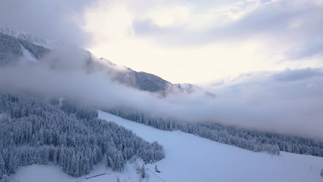 Dorf-Im-Winter,-Tal-Von-Sonnenbeschienenen-Wolken-Und-Nebeln-Verhüllt,-Dolomiten