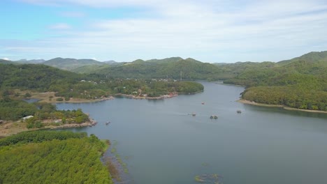 Die-Atemberaubende-Landschaft-Am-Huai-Krathing-Reservoir-In-Thailand-Mit-Ruhigem-Wasser-Und-Herrlichen-Bäumen-Unter-Dem-Strahlend-Blauen-Himmel-Darüber---Luftaufnahme