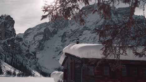 Verschneite-Holzhütte-Im-Sonnenschein,-Winterlicher-Pragser-Wildsee,-Dolomiten