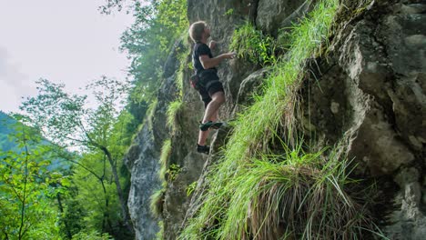 Young-adventurous-man,-bouldering-outdoors-on-steep-rocks-without-any-ropes
