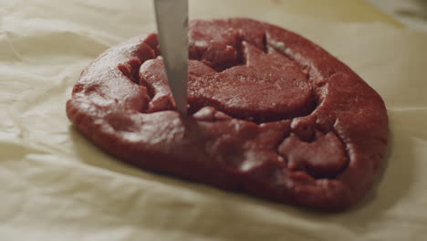 a-sharp-knife-outline-a-design-of-a-raw-cookie-dough,-static-close-up