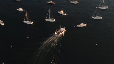 Ship-sailing-between-yachts,-vessels-and-boats-parked-in-the-atlantic-ocean