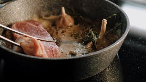 Piece-of-meat-layed-in-cast-iron-pot-with-sizzling-oil-garlic-and-rosemary