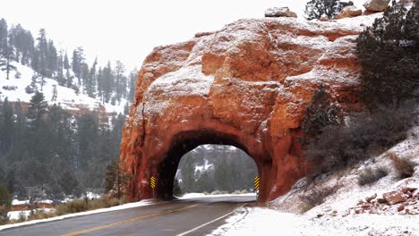 A-beautiful-natural-red-rock-arch-tunnel-in-the-middle-of-a-small-highway-in-southern-Utah
