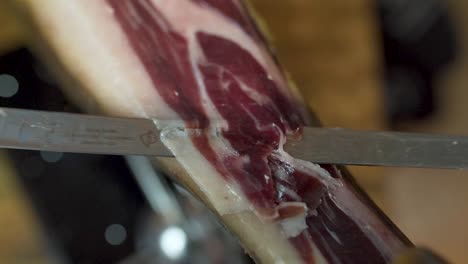 Close-up-Tracking-shot-of-Sharp-Knife-thin-slicing-Spanish-serrano-Ham