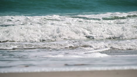 Slow-motion-shot-of-breaking-Waves-On-ocean-Shore-During-beautiful-summer-day