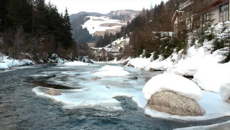 Kleines-Zugefrorenes-Flussufer-In-Verschneiter-Landschaft-Im-Winter
