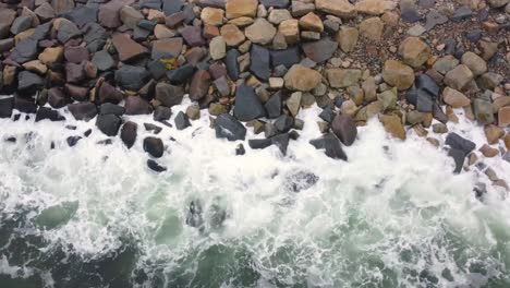 Sea-waves-hitting-rocks-background-seen-from-above,-birdseye-view-backdrop