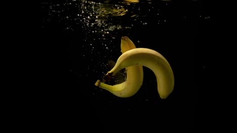 Zwei-Frische-Reife-Bananen,-Die-Zusammen-In-Das-Klare-Wasser-Fallen