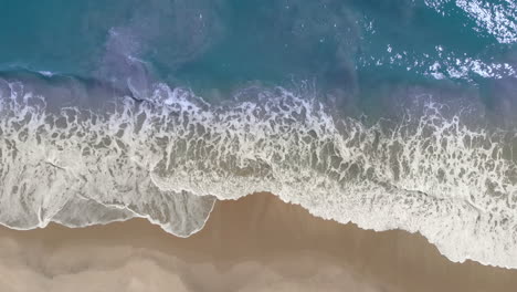 Luftaufnahme-Der-Sich-Windenden-Ozeanwelle,-Die-Die-Küste-Am-Tropischen-Goldenen-Strand-Erreicht