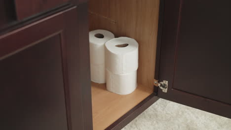 Man-stockpiling-toilet-paper-in-preparation-for-COVID-19,-Man-hoarding-toilet-paper-in-bathroom-cabinet,-white-Caucasian-male-filling-cabinet-with-TP-for-coronavirus-in-the-US-Worldwide-Pandemic-panic