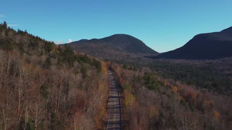 Carretera-De-Montaña-En-Un-Bosque-De-árboles-Secos-Con-Un-Cielo-Azul-En-New-Hampshire,-Ee.uu.