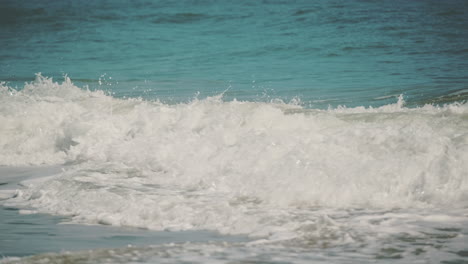 Slow-Motion-shot-of-Beautiful-Blue-Giant-Ocean-Wave-Crashing-at-golden-sandy-beach