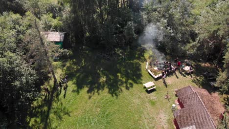 Drone-shot-of-a-camping-site-in-the-forrest-with-a-bonfire