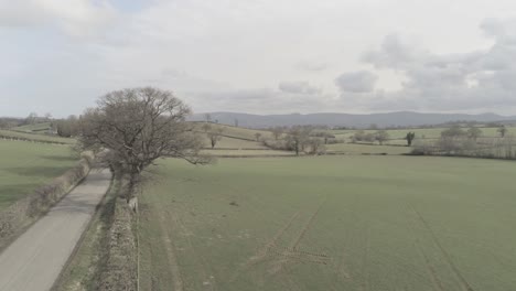 Idyllic-aerial-view-above-rural-countryside-long-farmland-road