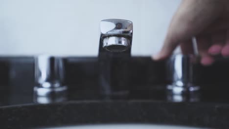 Closing-an-open-bathroom-faucet-in-slow-motion